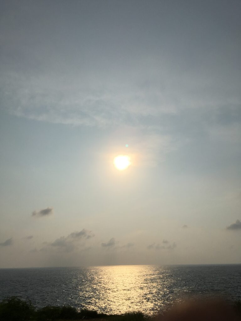 夕日の沈み始める海辺の写真